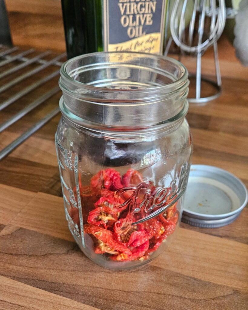 dried tomatoes in a jar ready to add in the olive oil and herbs.